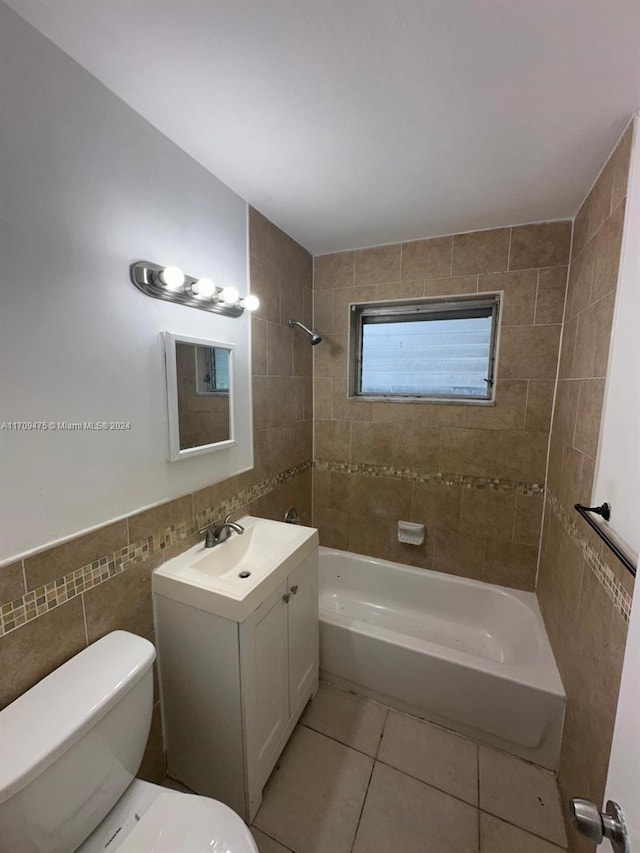 full bathroom featuring vanity, tiled shower / bath combo, tile walls, tile patterned flooring, and toilet