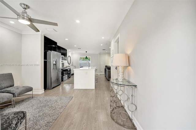 living room featuring light wood-type flooring, ceiling fan, and sink