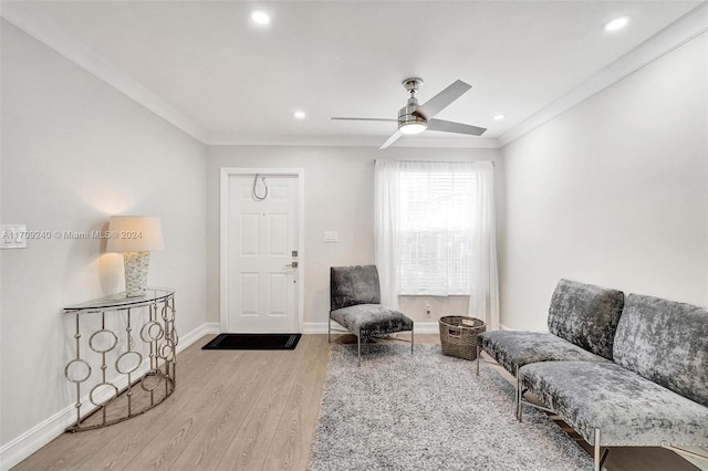 living room with crown molding, light hardwood / wood-style flooring, and ceiling fan