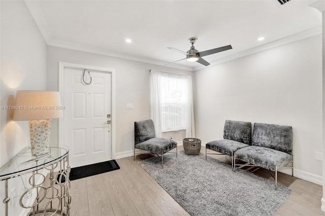 living room featuring light wood-type flooring, ceiling fan, and crown molding