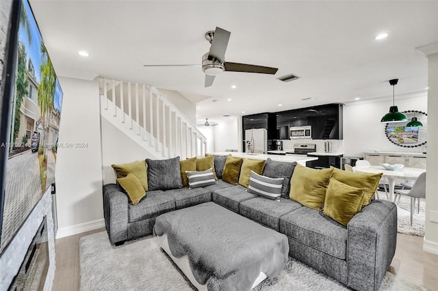 living room featuring ceiling fan and light hardwood / wood-style flooring