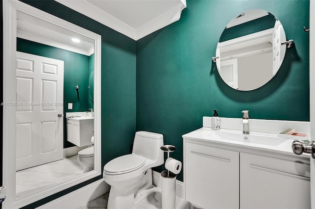 bathroom with vanity, toilet, and crown molding