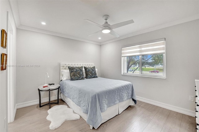 bedroom with light wood-type flooring, ceiling fan, and ornamental molding