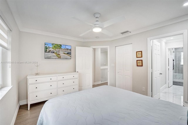 bedroom with ceiling fan, ensuite bathroom, light hardwood / wood-style floors, multiple windows, and ornamental molding