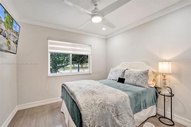 bedroom featuring ceiling fan, light wood-type flooring, and ornamental molding