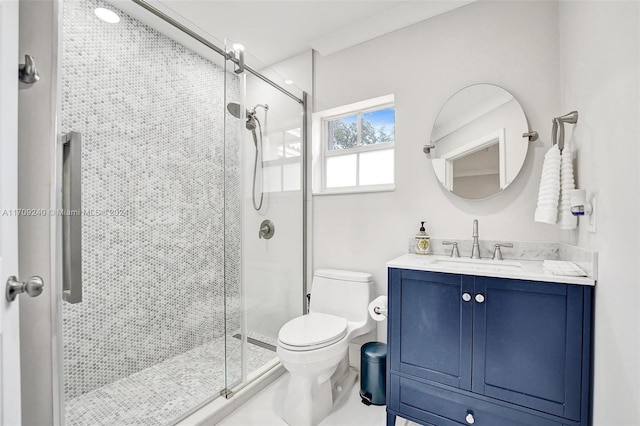 bathroom featuring vanity, toilet, and a shower with door