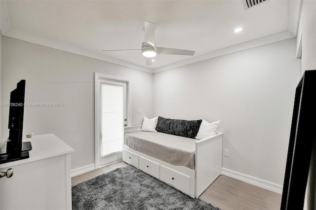 bedroom featuring ceiling fan, light hardwood / wood-style floors, and ornamental molding