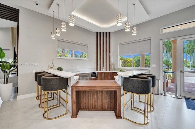 interior space featuring light tile patterned floors, a tray ceiling, and plenty of natural light