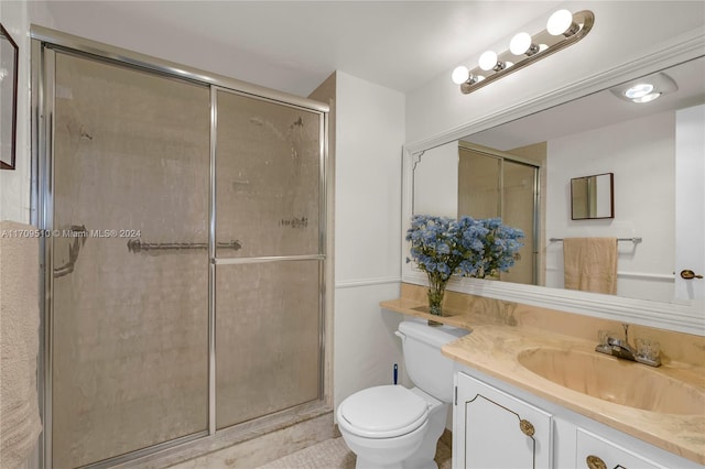 bathroom with vanity, toilet, and a shower with shower door