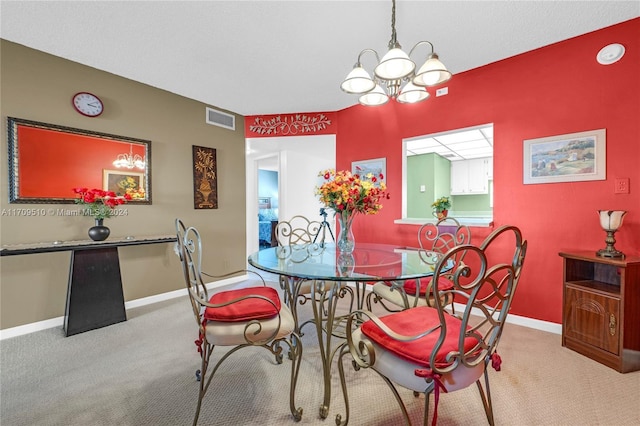 carpeted dining room featuring a chandelier