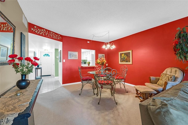 carpeted dining space featuring a textured ceiling and an inviting chandelier