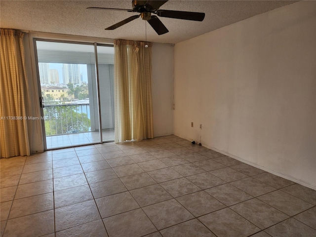 tiled empty room featuring a textured ceiling and ceiling fan