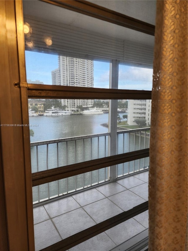 doorway featuring tile patterned flooring and a water view