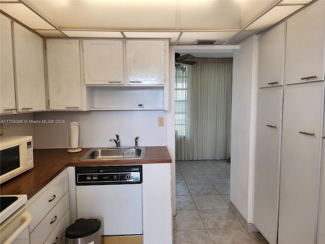 kitchen featuring white cabinetry, white appliances, sink, and light tile patterned floors