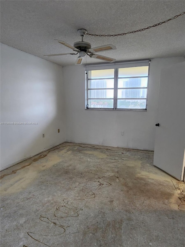 spare room featuring plenty of natural light, ceiling fan, and a textured ceiling