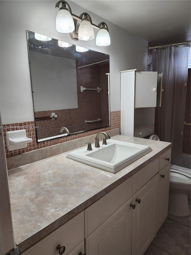 full bathroom featuring tile patterned floors, shower / bath combo with shower curtain, vanity, and toilet