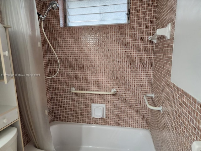 bathroom featuring toilet and shower / bath combo with shower curtain