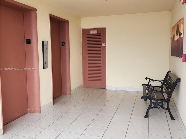 corridor with light tile patterned floors and elevator