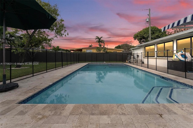 pool at dusk with a patio area