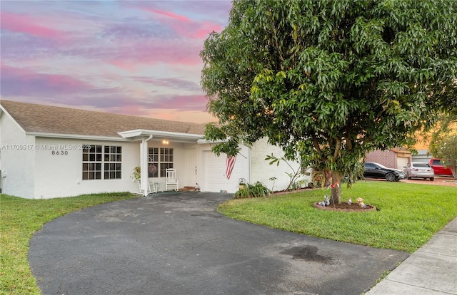 view of front of home with a lawn and a garage