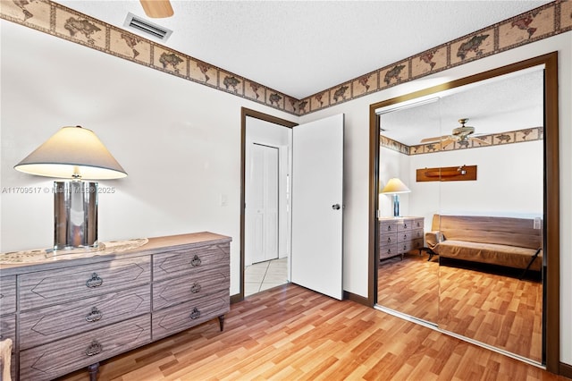 bedroom featuring a closet, a textured ceiling, and light wood-type flooring