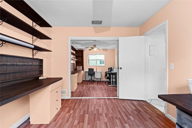 hall featuring a textured ceiling and light wood-type flooring