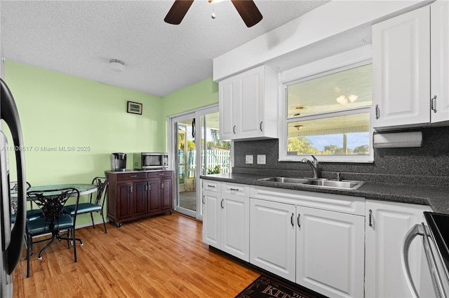 kitchen featuring white cabinetry, sink, ceiling fan, and a textured ceiling