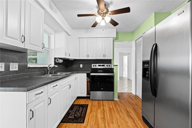 kitchen with ceiling fan, sink, appliances with stainless steel finishes, white cabinets, and light wood-type flooring