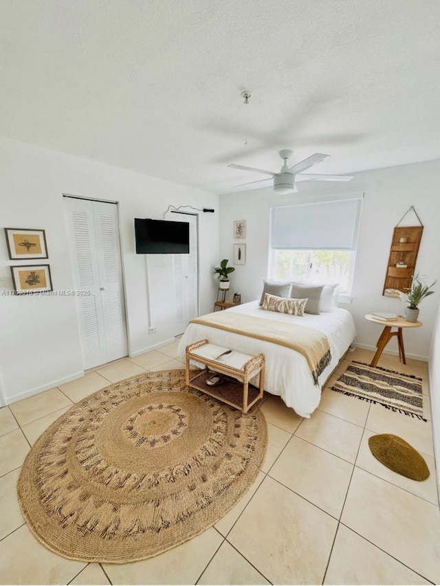 tiled bedroom featuring a textured ceiling and ceiling fan