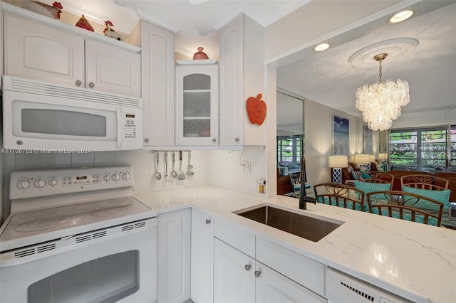 kitchen featuring white cabinetry, an inviting chandelier, tasteful backsplash, pendant lighting, and white appliances