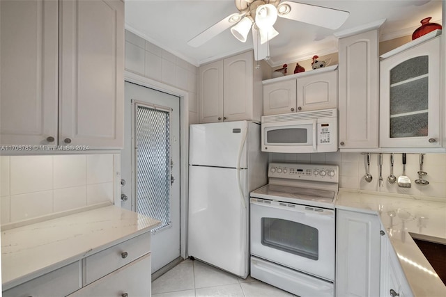 kitchen featuring backsplash, ornamental molding, white appliances, light tile patterned floors, and white cabinetry