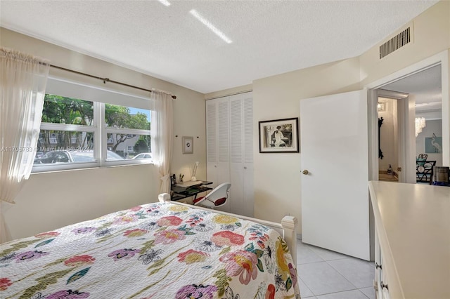 tiled bedroom featuring a textured ceiling and a closet