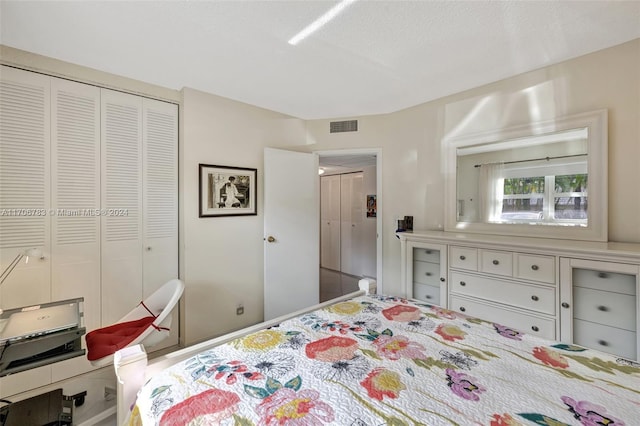 bedroom with a textured ceiling and a closet