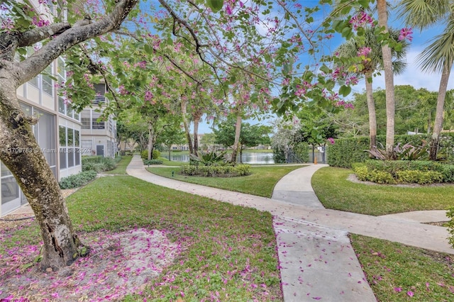 surrounding community featuring a lawn and a water view