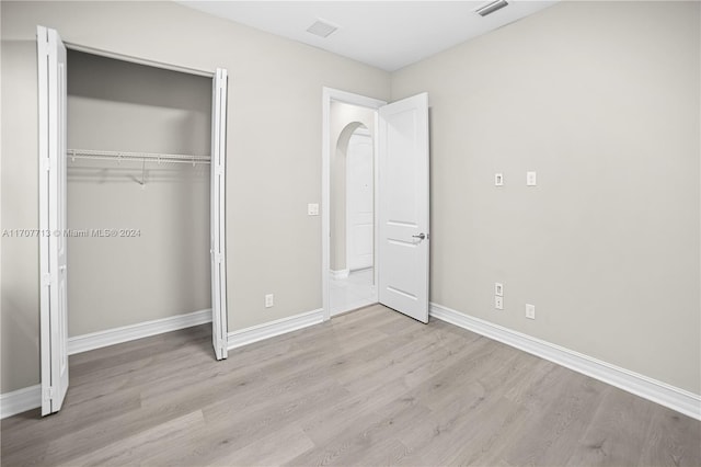 unfurnished bedroom featuring a closet and light hardwood / wood-style flooring