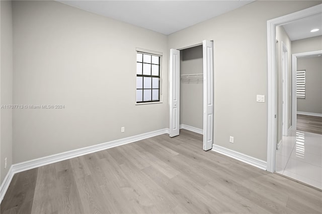 unfurnished bedroom featuring a closet and light hardwood / wood-style floors