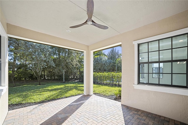 unfurnished sunroom featuring ceiling fan