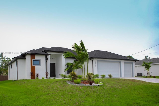 view of front facade featuring central AC, a garage, and a front lawn