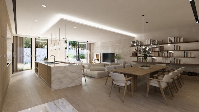 dining space with an inviting chandelier, a wall of windows, sink, and light hardwood / wood-style flooring