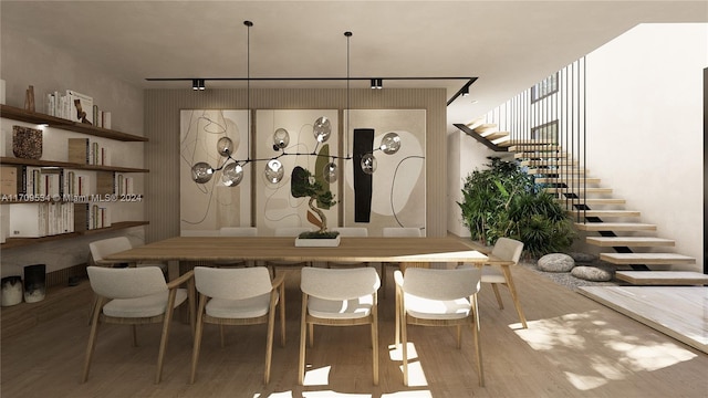 dining space with hardwood / wood-style floors and track lighting