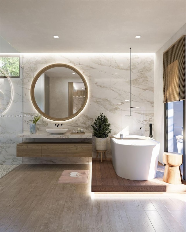 bathroom featuring hardwood / wood-style floors, a bathing tub, and tile walls