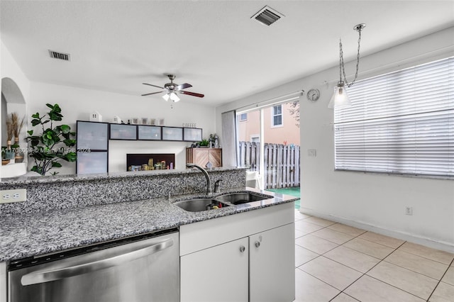 kitchen featuring dishwasher, white cabinets, sink, stone countertops, and light tile patterned flooring