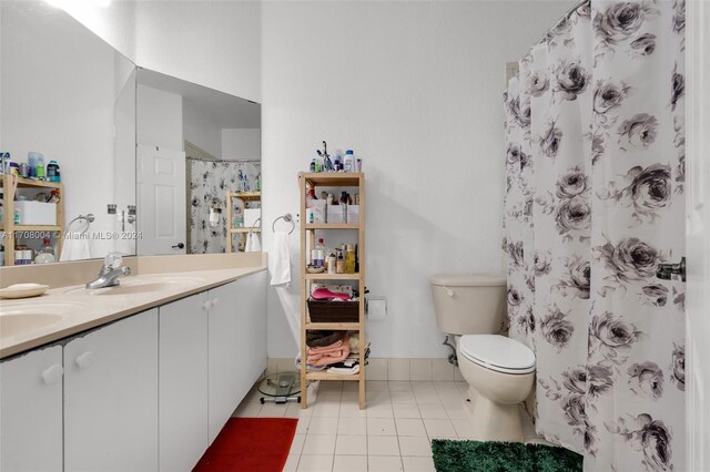 bathroom with curtained shower, tile patterned flooring, vanity, and toilet