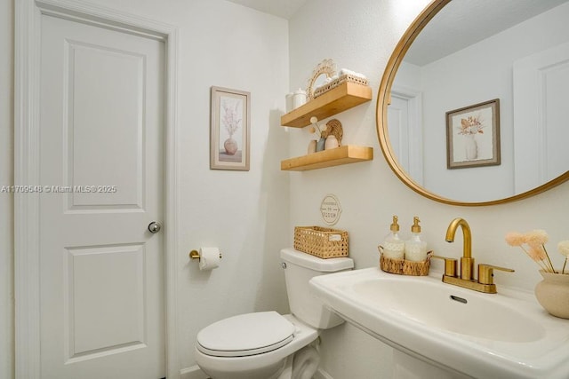 bathroom featuring toilet and sink