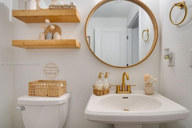 bathroom featuring toilet and sink