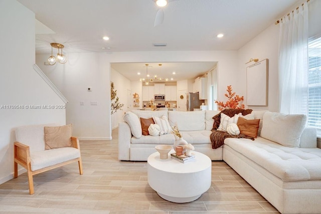 living room featuring light hardwood / wood-style floors, a healthy amount of sunlight, and a notable chandelier