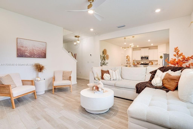 living room featuring light wood-type flooring and ceiling fan