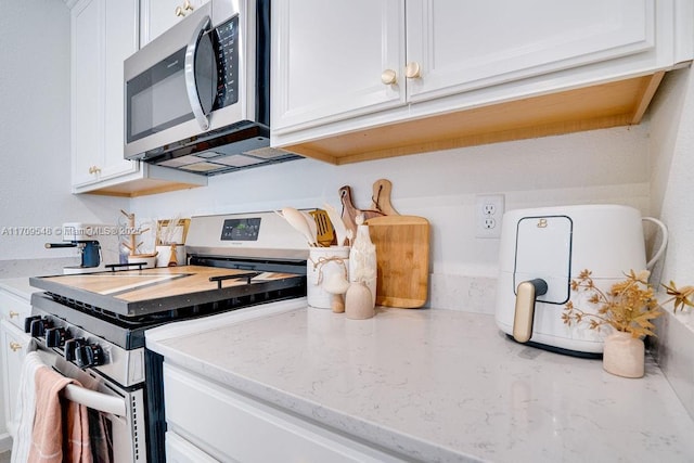 kitchen featuring white cabinets, light stone countertops, and stainless steel appliances