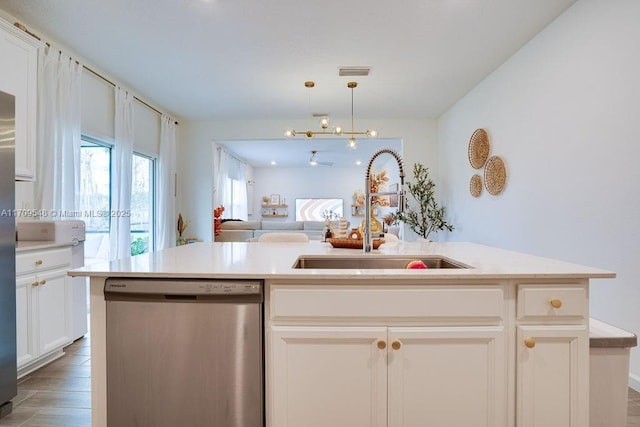 kitchen featuring a center island with sink, dishwasher, white cabinetry, and sink