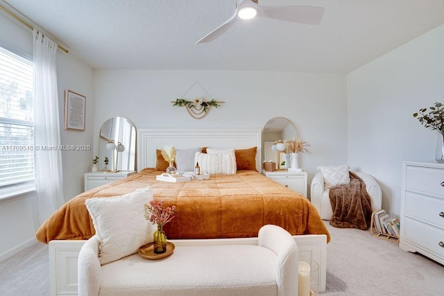 bedroom with ceiling fan, light colored carpet, and multiple windows